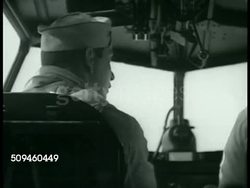 1938: MEDICAL ASSISTANCE: CU Airplane dispatch board w/ V-115 'in flight.' INT Coast Guard airplane, pilots, radio operator, pilot pointing. WS Trawler on water, sailors loading sick crew member into boat, PJ-1 flying boat on water w/ boat approaching Instructional Video