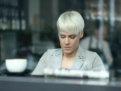 Young woman drinking coffee and using tablet Stock Footage