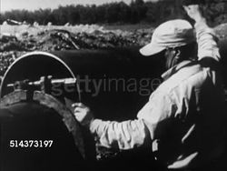 1952: CANADA: INTERPROVINCIAL PIPELINE: VS Workers moving pipes w/ heavy equipment, joining pipe, tightening clamps, VS Welders welding, CU Welding using stick welder, sparks flying, bright light.       Construction, rural, west to east, extension. Instructional Video