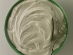 Spoon scoops yogurt from green bowl Stock Footage