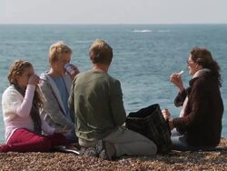 MS, Family with two children (10-11, 12-13) having picnic on Brighton beach, Brighton, Sussex, United Kingdom Stock Footage