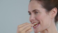 Portrait of radient, 40yrs + woman taking a vitamin pill looking off camera Stock Footage