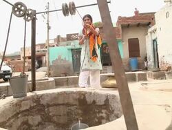 Woman taking out water from well, Faridabad, Haryana, India  Stock Footage