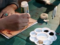 leatherworker paint fish pattern on leather Stock Footage