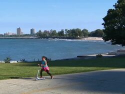 Girl Riding Scooter Near Lake Michigan Stock Footage