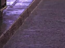 Puddles collect on a city street near a sidewalk on a rainy day in New York City. Stock Footage