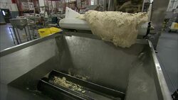 A roller deposits pretzel dough into a vat. Stock Footage