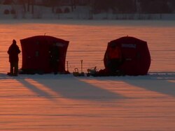 WS People standing on frozen lake by their ice fishing shelters / Minneapolis, Minnesota, United States Stock Footage