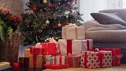 Christmas gifts on living room floor in front of Christmas tree Stock Footage