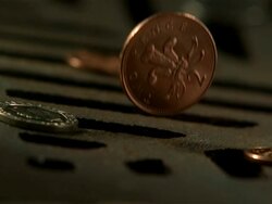 Money Down the Drain - High speed English coin, 2p with Prince of Wales feathers design, falling on and in to road drain, knocks 20p, low angle 2, BCU Stock Footage