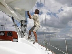 man hoisting sail on moving yacht /tampa,florida,USA Stock Footage