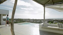 Woman photographing view on luxury patio overlooking ocean Stock Footage