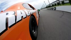 Orange stock-car driver trails behind green race-carAn orange stock car races along a track. Stock Footage