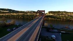 Angled Deep Perspective Pennybacker Bridge or 360 Bridge or Capital of Texas Highway Bridge at Sunset on the Colorado River or Town Lake Spring Time Aerial Sunset golden hour angled from Rare side of the 360 Bridge Stock Footage