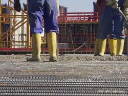Workers Directing Concrete Onto The Construction Site Stock Footage