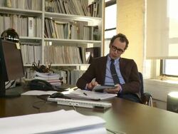 Medium shot. Camera dollies to the left as man works on iPad. Stock Footage