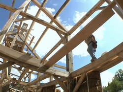 WS Carpenter working in rafters while framing an energy efficient post / Grass Lake, Michigan, USA  Stock Footage
