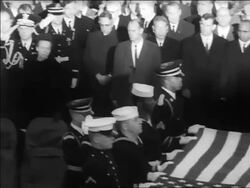 B/W 1963 zoom out PAN from Lyndon Johnson with hand over heart to military holding flag over JFK's coffin Stock Footage