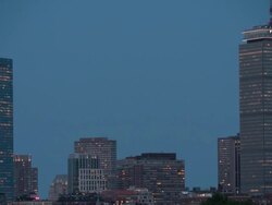 Amazing med w/s shot of super full moon rising over Boston Downtown after dark. TL day to night Stock Footage