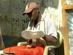 Cobbler rubbing white tennis shoes Stock Footage