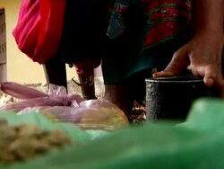 Woman pouding roasted coffee grains for coffee ceremony Stock Footage