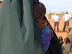 Refugee Baby being carried on mother's back Stock Footage
