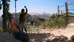 Young Brazilian boy swings on rope swing as friend cheers him on Stock Footage