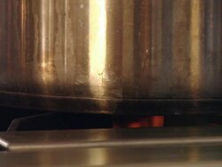The flame of a gas stove heats a aluminum cauldron  Stock Footage