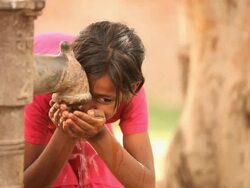 Girl drinking water from handpump, Faridabad, Haryana, India Stock Footage