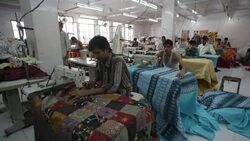 Men sit at sewing machines in a garment factory. Stock Footage