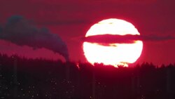 Extreme large Sunset with polluting smokestack  against red sky Stock Footage