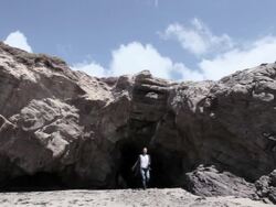 Group of young friends emerging from cave Stock Footage