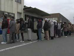 Aftermath of tsunami after magnitude 9 Tohoku earthquake, north east Japan, March 2011. People queue up outside shop in Osaki city Stock Footage