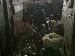 MS Shot of men breaking up metal components / Lagos, Nigeria Stock Footage