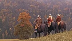 DS Two cowboys and a cowgirl riding horses in mountains Stock Footage