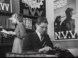 Woudenberg gives a speech in front of the camera. During the speech there are images shown of workers at work Stock Footage