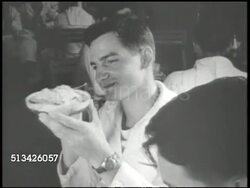 1940s: UNITED STATES NAVY: OAHU NAVAL BASE: VS U.S. Navy submariners being served in Royal Hawaiian Hotel dining hall, eating dessert. EXT VS Service men swimming on surfboard, paddling in canoe. WWII, Pacific Front, O'ahu, Hawaii, recreation, leave Instructional Video