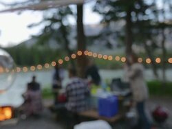 Friends hanging out near campfire at campsite Stock Footage