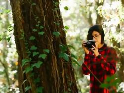 Hipster girl taking photo in the forest Stock Footage