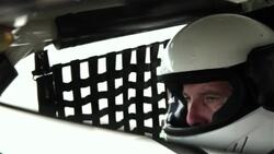 Stock-car driver's reflection in rearview mirror Stock Footage