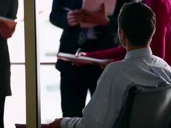CU PAN Businessman sitting at conference table in discussion with businesswoman examining documents in folder/Washington, USA Stock Footage