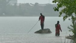 Coast guard officer holding diver's line in lake Stock Footage
