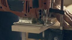 Electric jigsaw sawing piece of wood Stock Footage