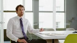 MS R/F Businessman in discussion with coworker while seated at table in conference room Stock Footage
