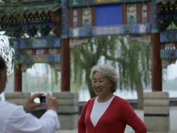MS Mature man taking photo of elderly woman in front of traditional Chinese gate / Beijing, China Stock Footage