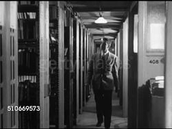 1951: HARVARD UNIVERSITY: LIBRARY: WS People walking down steps w/ columns BG, MS Male student handing paper to woman at desk, walking book aisle, WS Shelf end signs American Literature books by date, student using card catalog, filling out request. Instructional Video