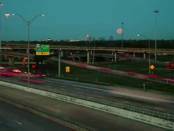 Night time, time lapse, wide vista of traffic on complex interstate system, moon sets in background. Stock Footage
