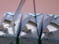 Close up hand removing wand of digital pH meter from open milk carton Stock Footage