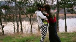 A loving couple cuddling pup in nature Stock Footage