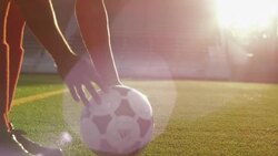 Close-up player's feet as he dribbles ball into frame; he picks up ball &amp; moves farther away from camera Stock Footage